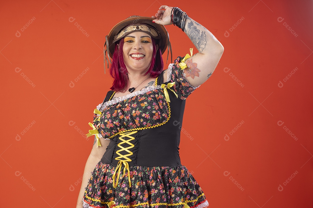 Jovem com trajes juninos e mão no chapéu