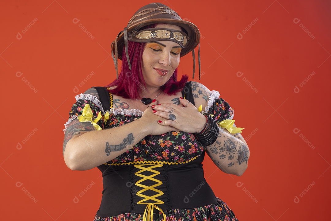 Uma mulher com traje junino e mãos no coração