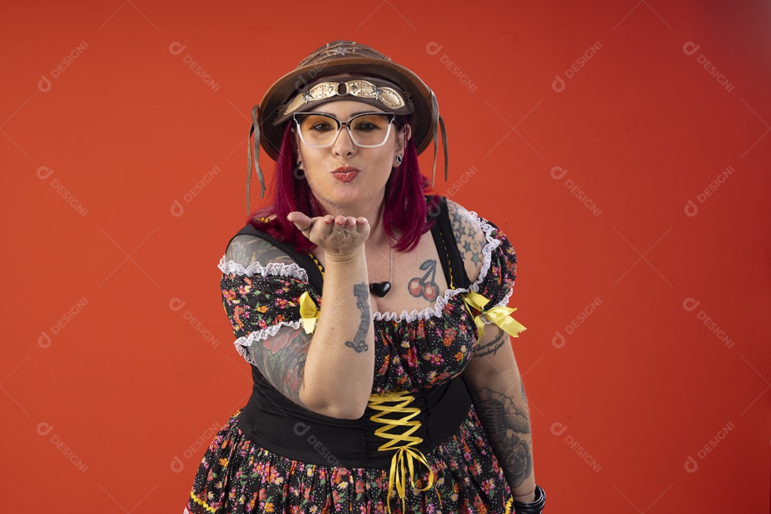 Jovem com trajes de quadrilha junina mandando beijo