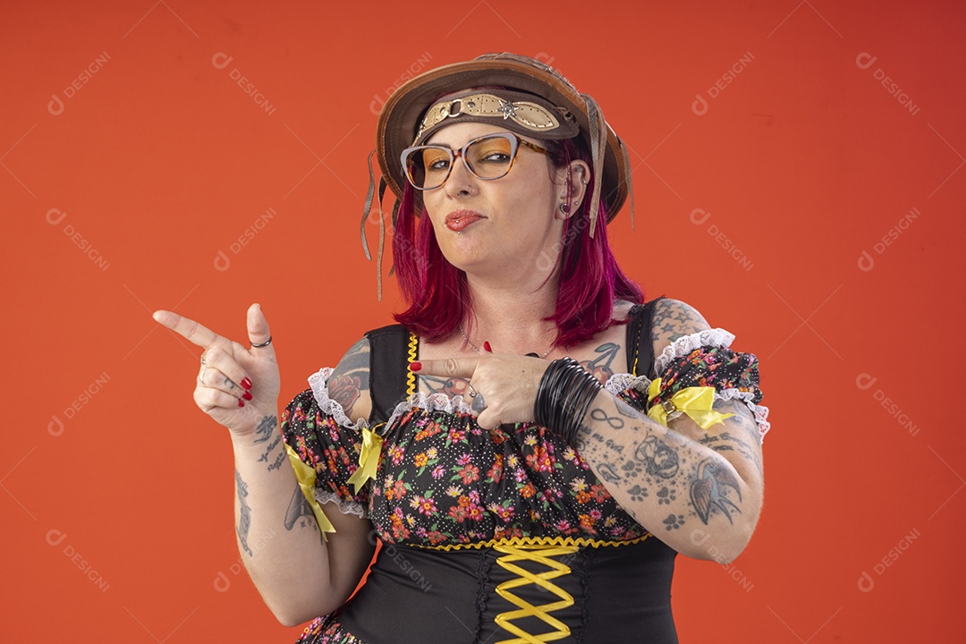 Jovem garota com trajes juninos sorrindo apontando para lado