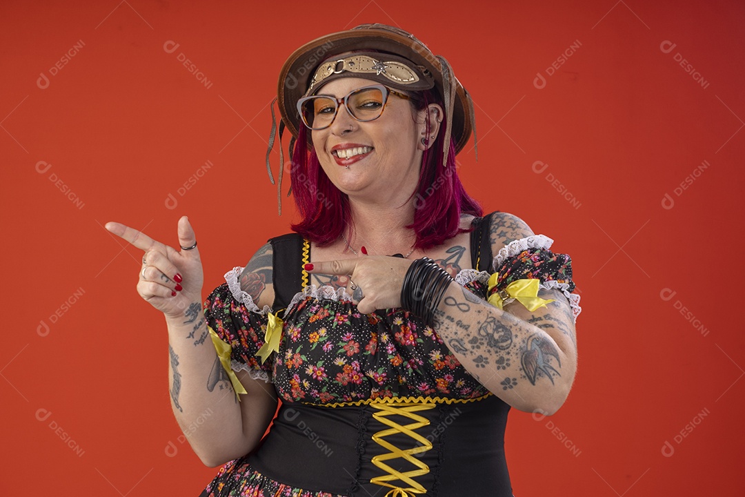 Jovem garota com trajes juninos sorrindo apontando para lado