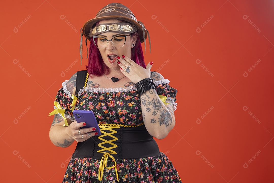 Mulher vestida a caráter para festa junina com celular na mão