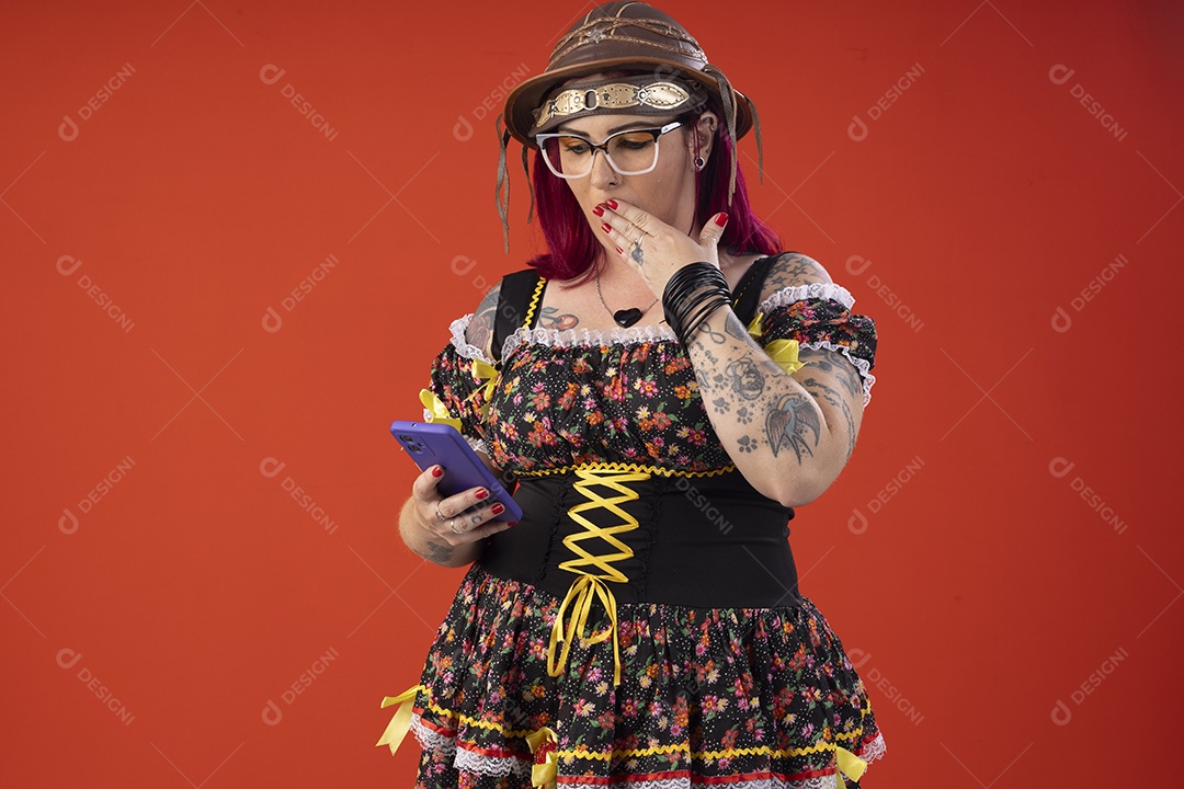 Mulher vestida a caráter para festa junina com celular na mão