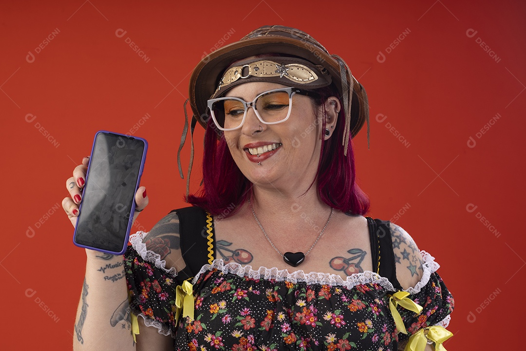 Mulher vestida a caráter para festa junina com celular na mão