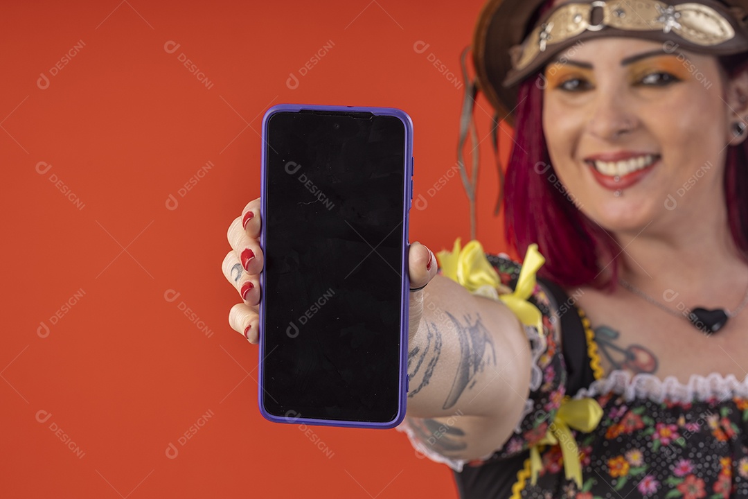Mulher vestida para festa junina mostrando celular na mão