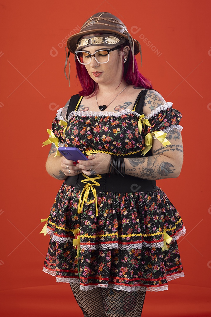 Mulher vestida a caráter para festa junina com celular na mão