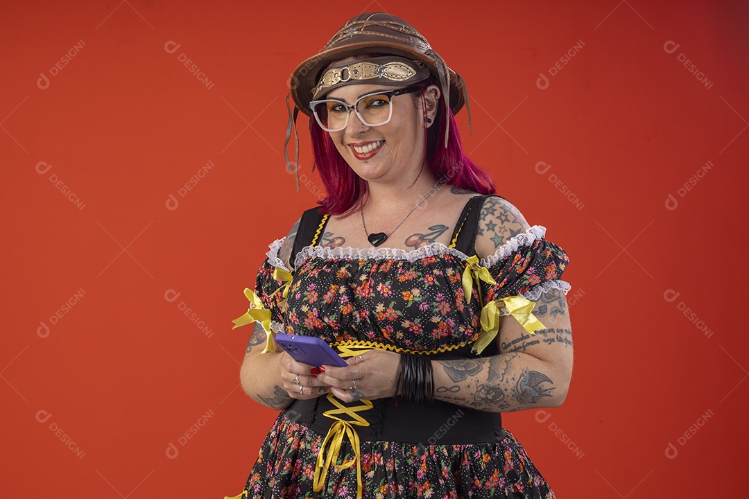 Uma mulher vestida a caráter para festa junina com celular na mãos