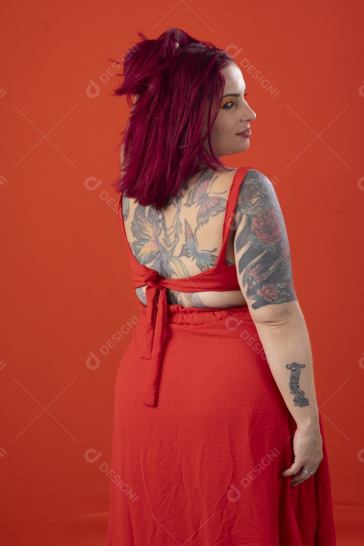 Uma mulher bonita fofa tatuada usando vestido vermelho