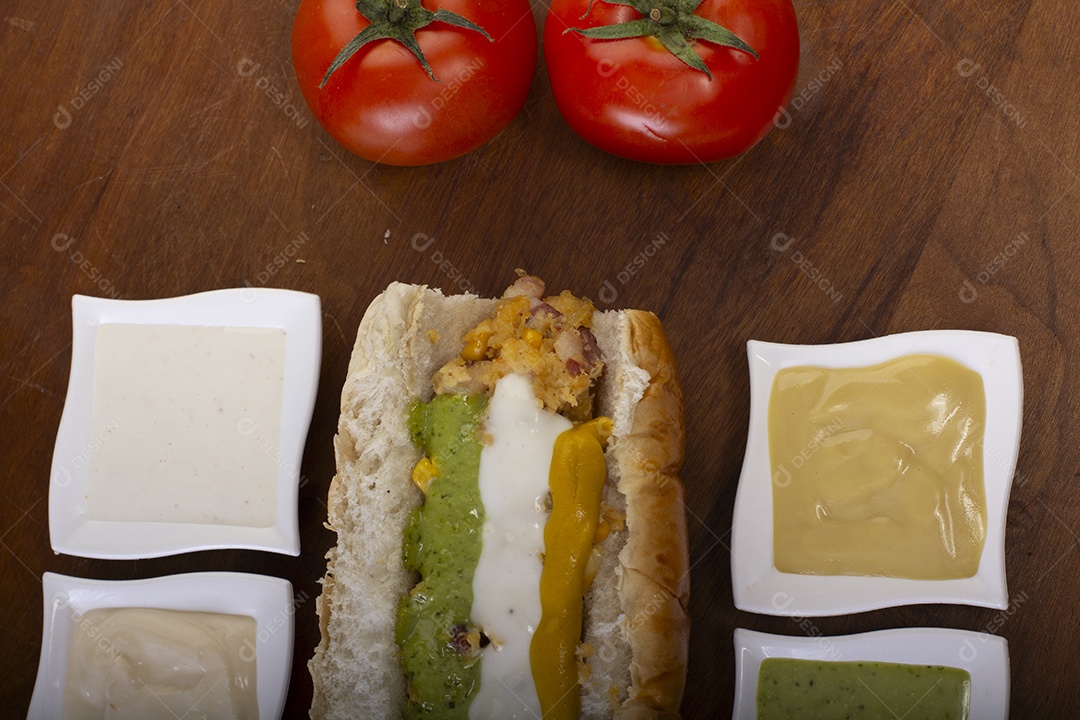 Cachorro quente com molhos deliciosos e tomates a frente