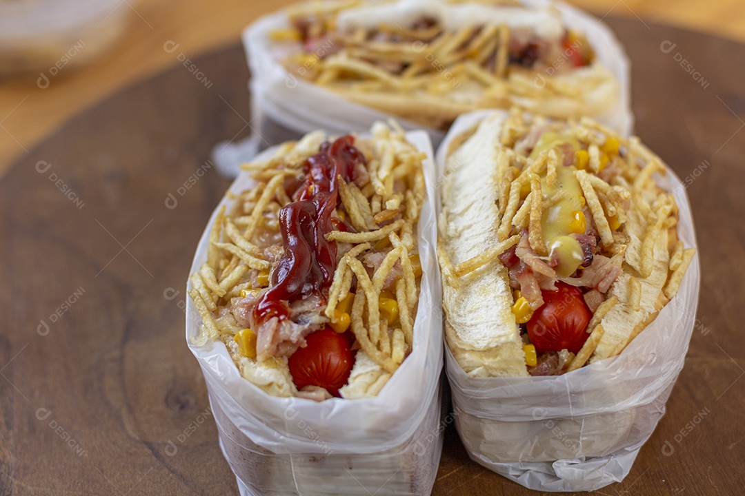 Três hotdog delicioso sobre mesa de madeira