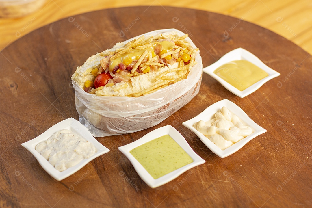 Tábua de madeira com cachorro quente e molhos delicioso