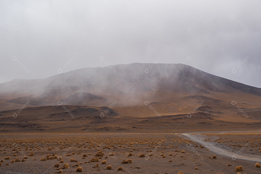 Montanha parcialmente coberta por nuvens em um deserto na Bolívia