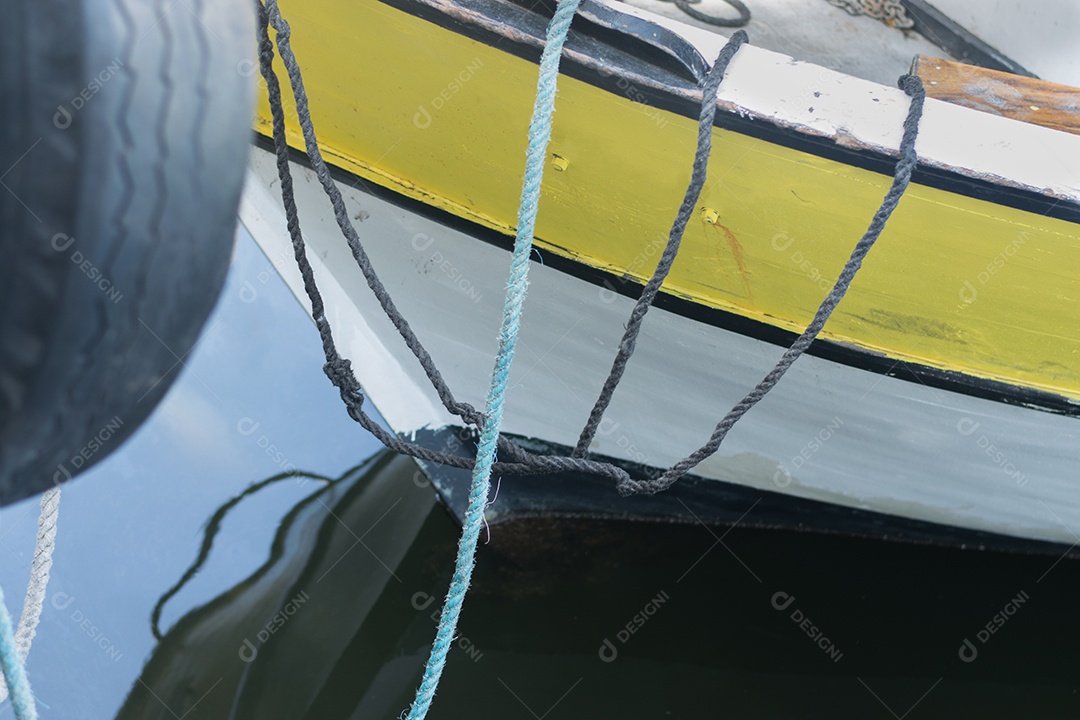 Reflexão de barco e cordas na água