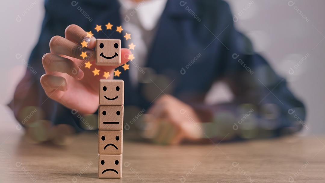 A mão de um empresário escolhe um rosto sorridente em um círculo de blocos de madeira