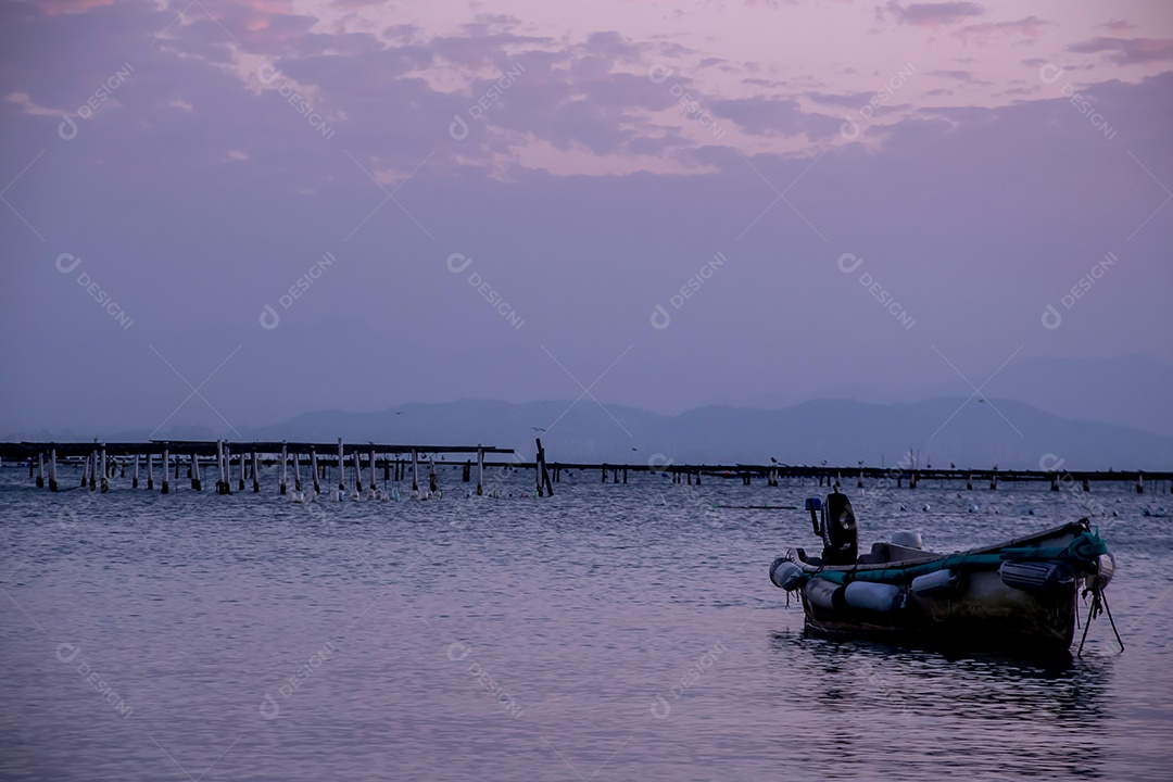 Pôr do sol no mar canoa com montanhas ao fundo