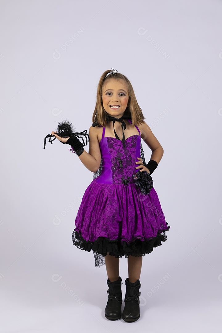 Menina fofa linda segurando aranha e fantasiada para halloween