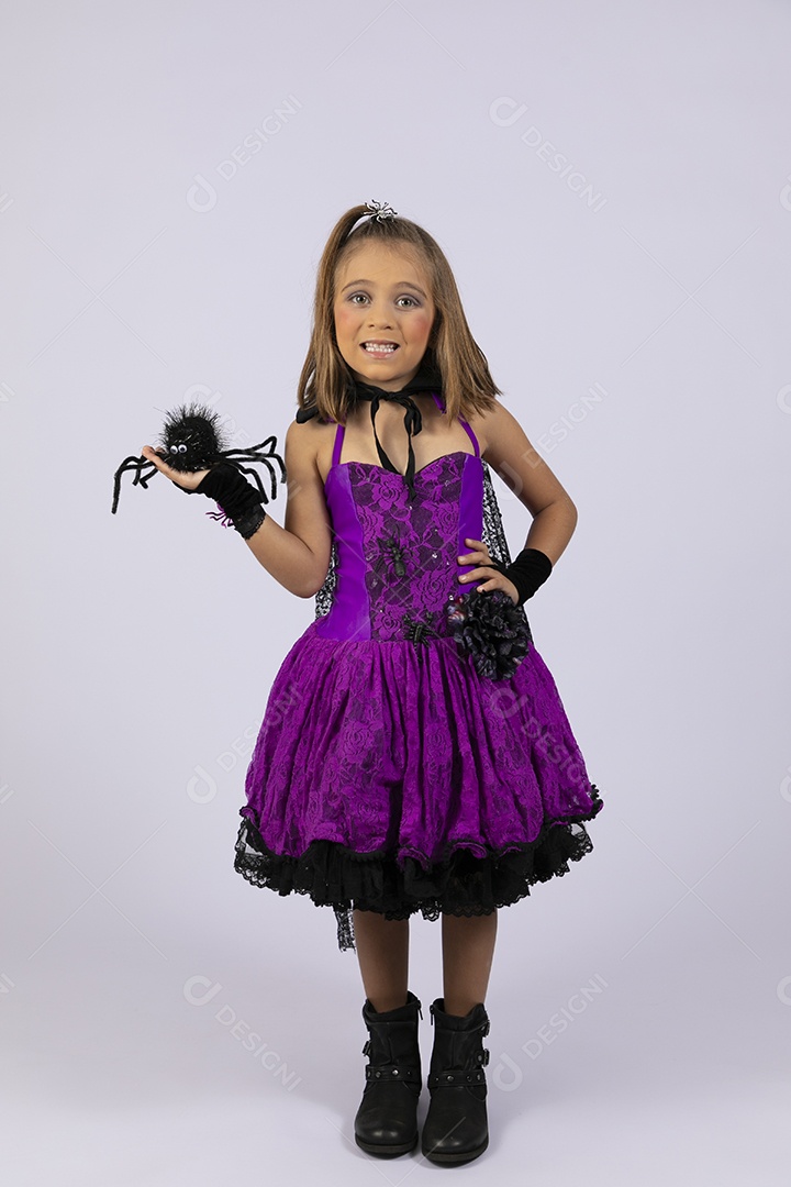 Menina fofa vestida para halloween com aranha na mão