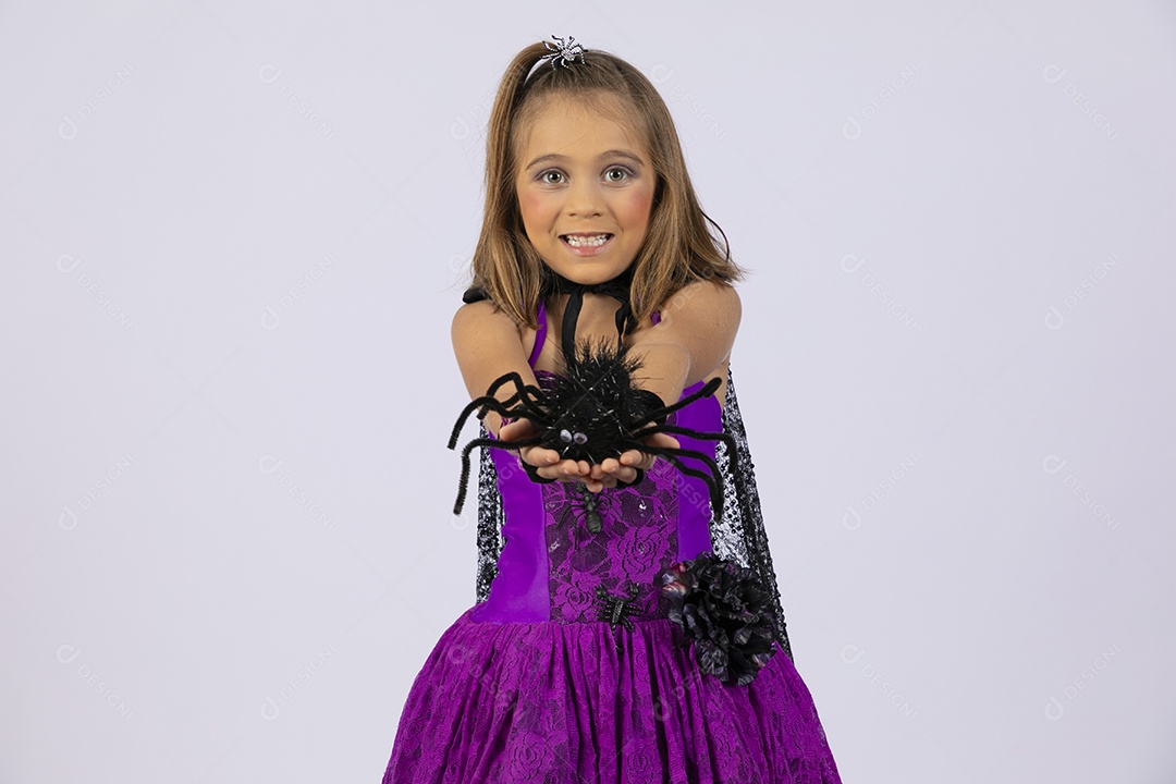 Menina fantasiada com uma aranha na mão para halloween