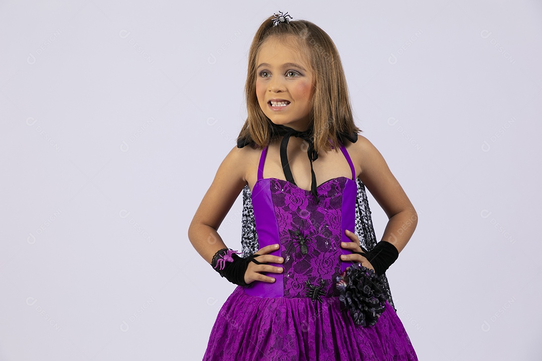 Menina fofa sorrindo fantasiada para halloween com mãos na cintura