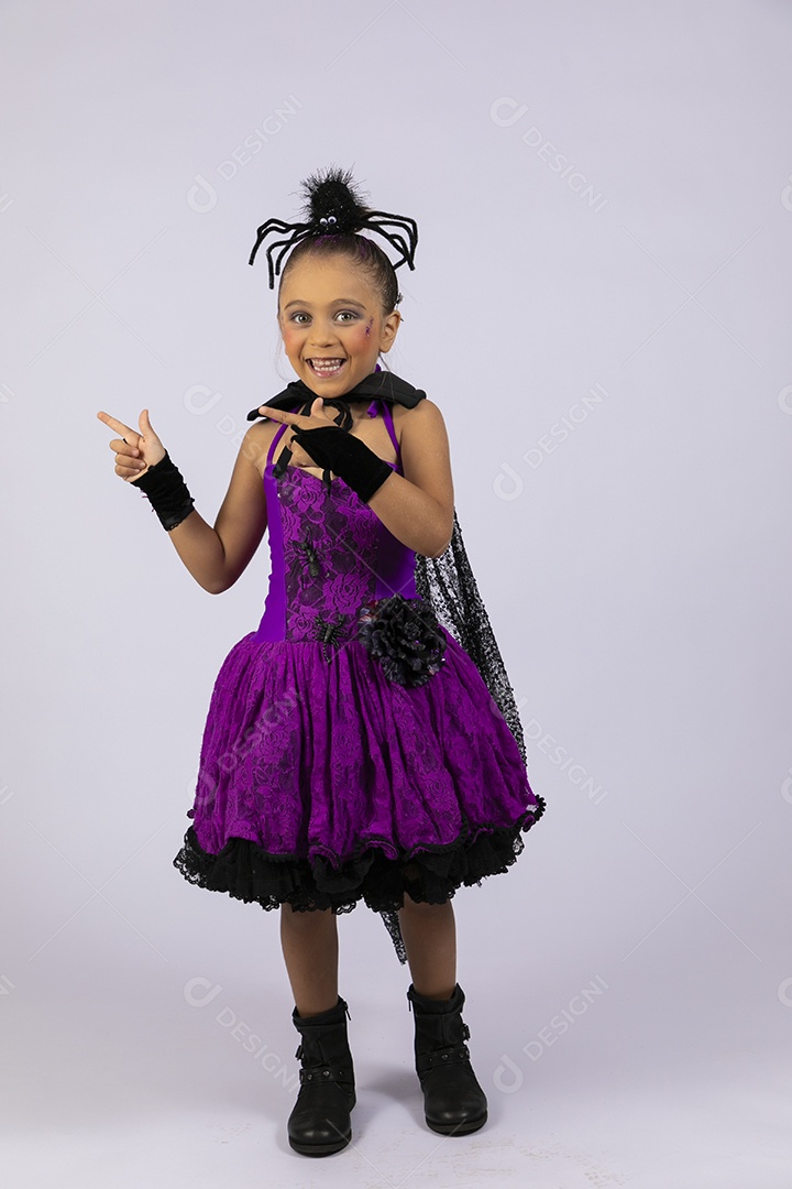 Menina linda fantasiada de aranha para halloween apontando pra o lado