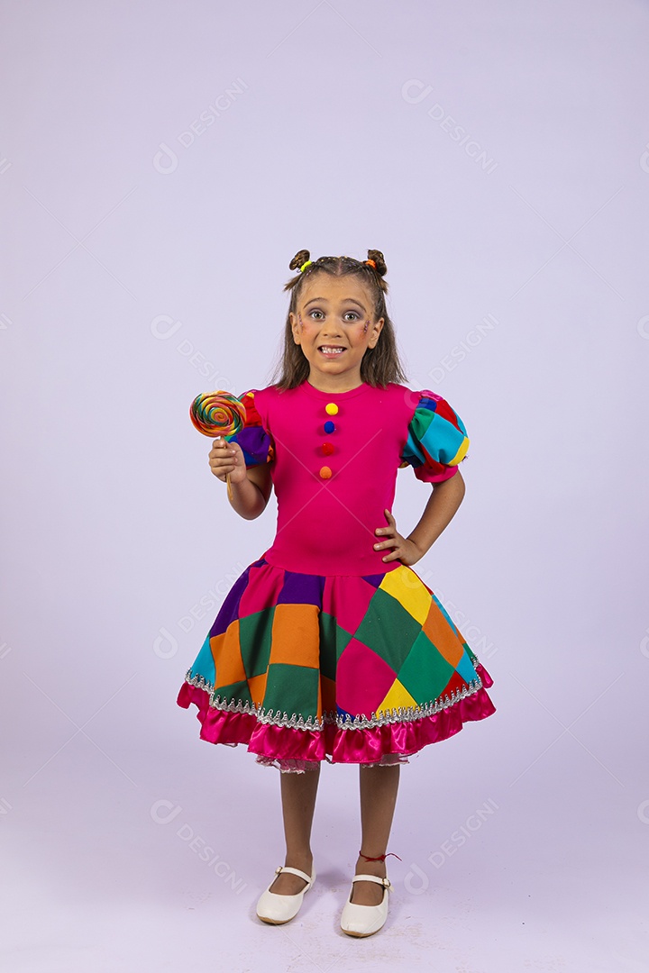 Garotinha fofa com roupa colorida segurando pirulito e sorrindo