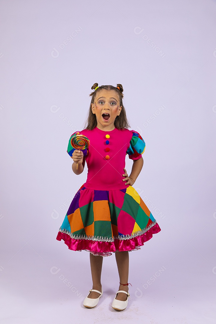 Uma menina linda com roupa colorida e pirulito na mão com gesto de surpresa