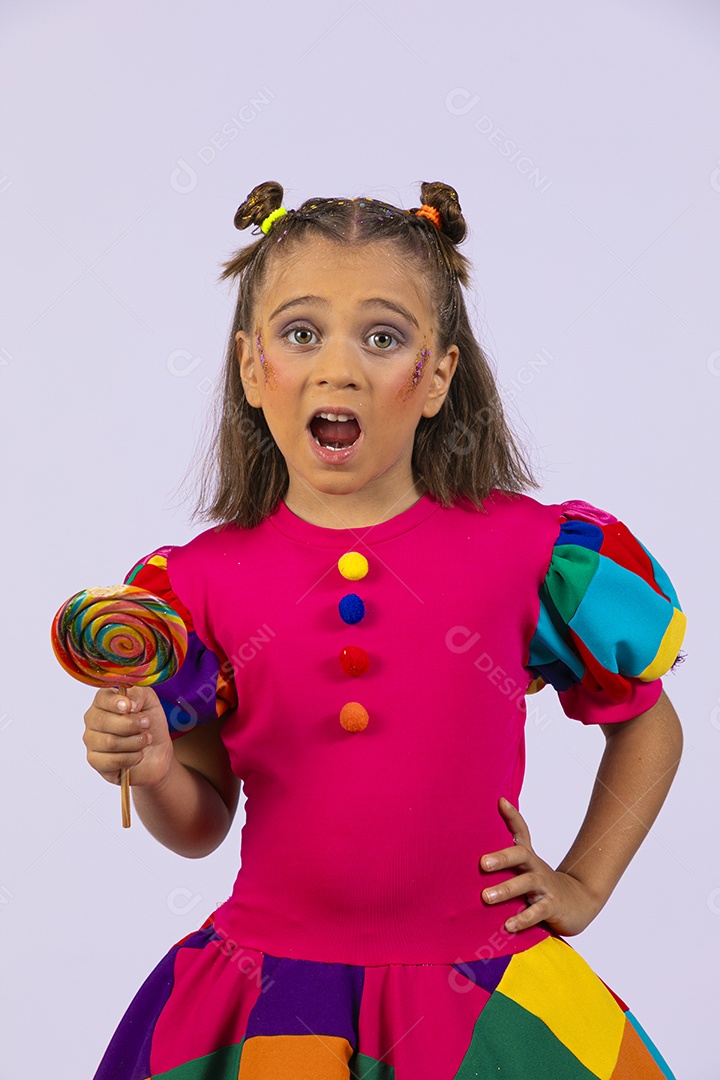 Menina fofa fantasiada com uma roupa colorida com um pirulito na mão