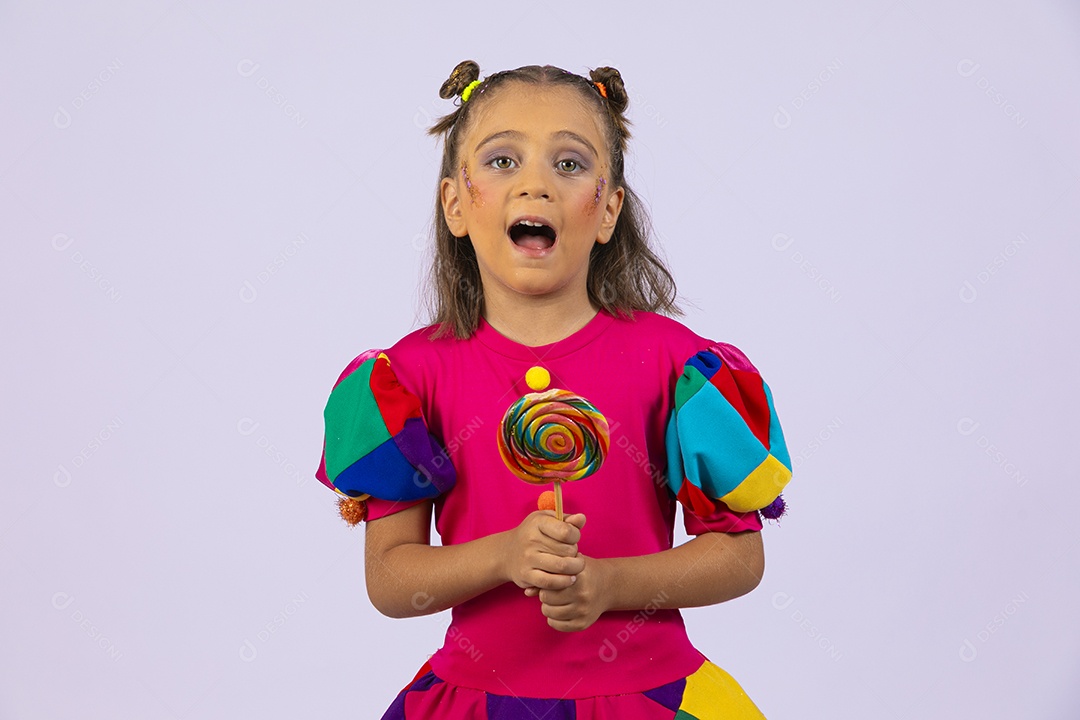 Menina fofa fantasiada com roupa colorida segurando pirulito