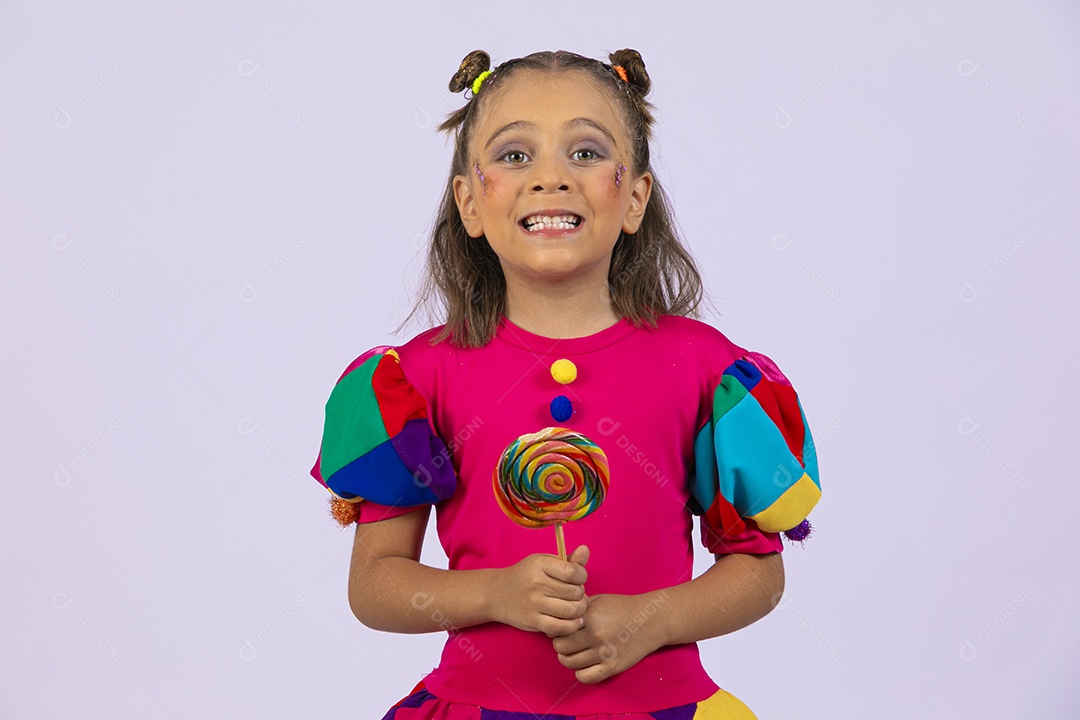 Uma linda menina feliz segurando um pirulito colorido