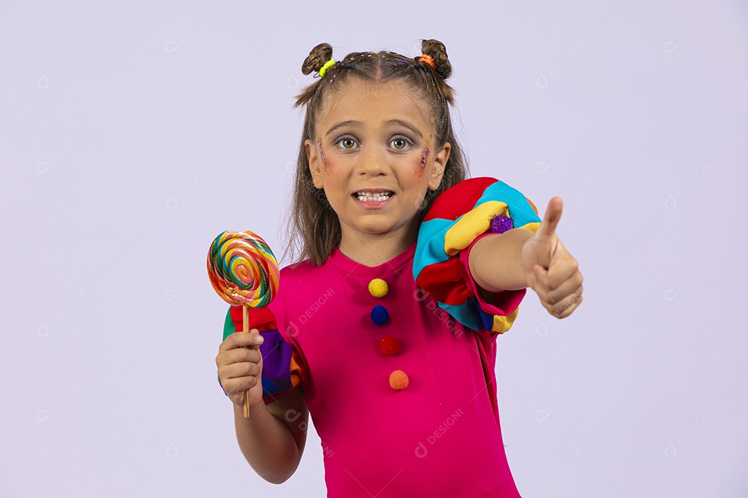 Uma menina linda com roupa colorida e pirulito na mão com gesto legal