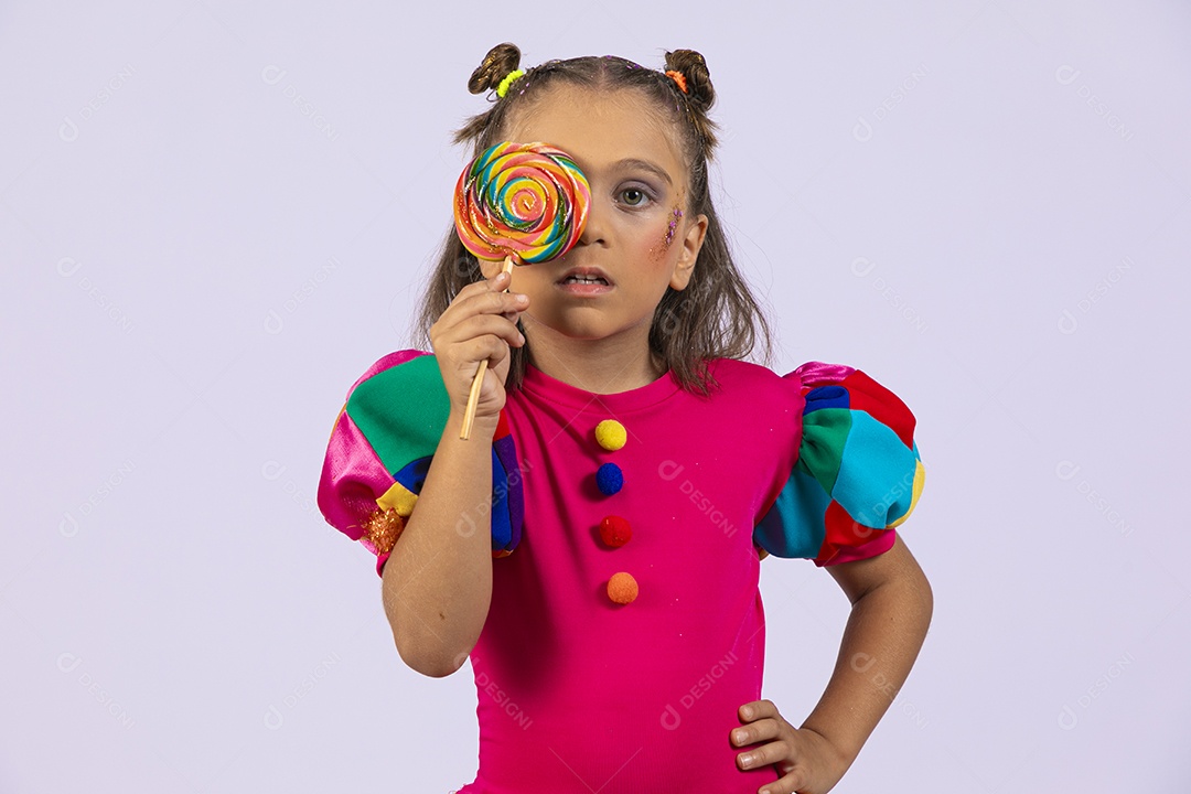 Uma menininha com mãos na cintura e um pirulito no olho