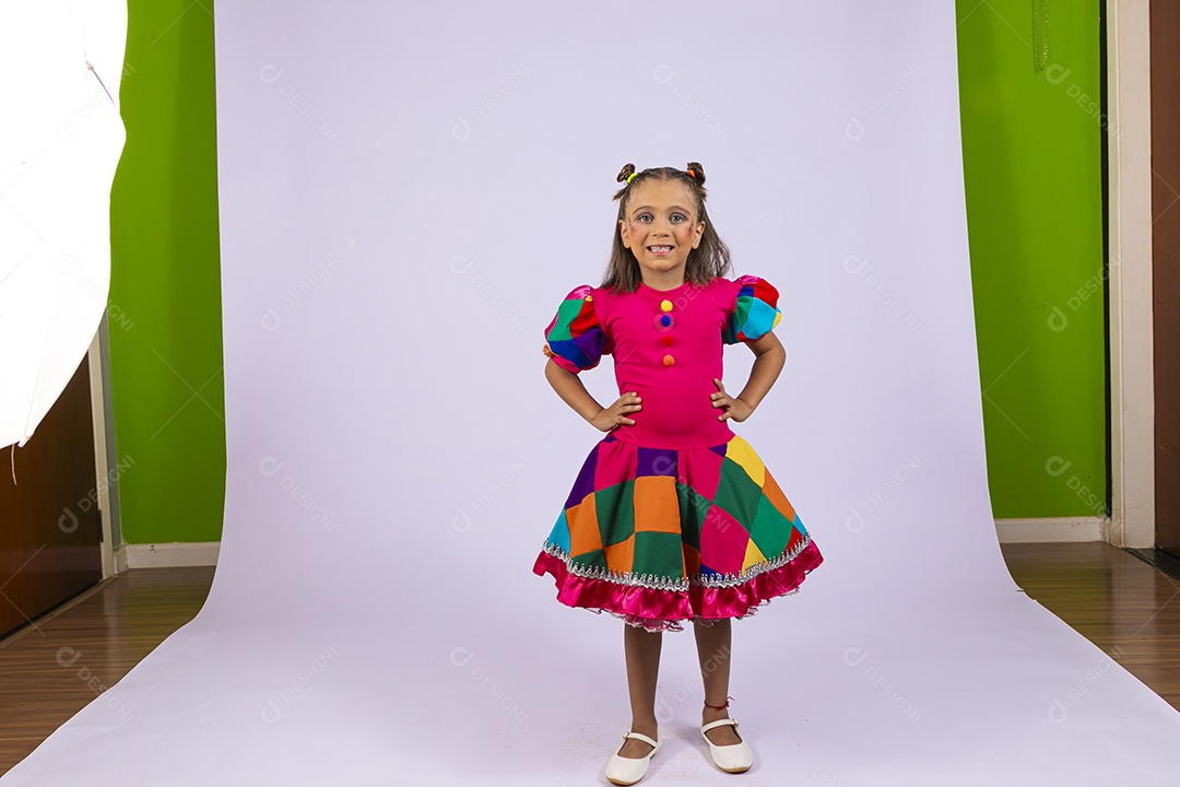 Menina fofa com mãos na cintura e roupa colorida