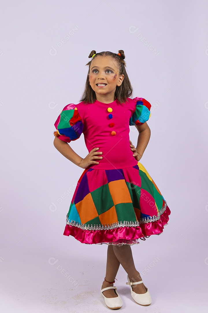 Uma linda garotinha maquiada com roupa colorida mãos na cintura feliz