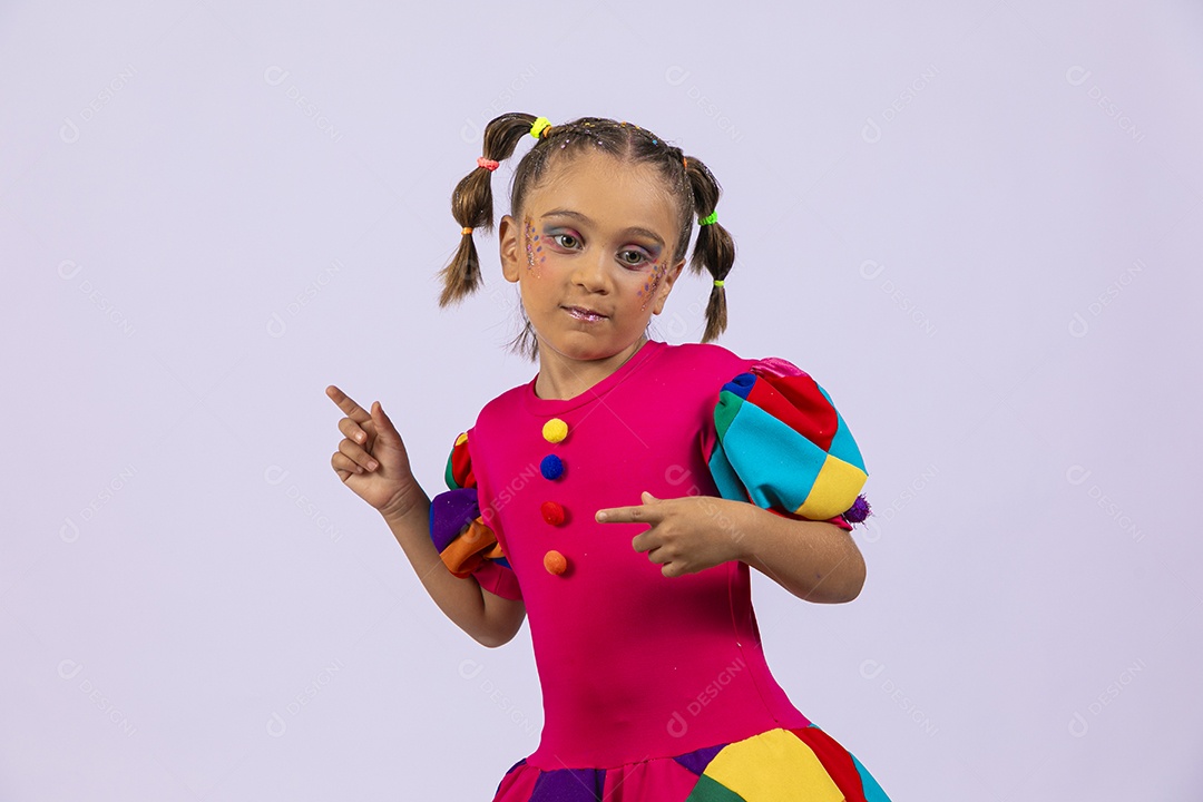 Menina fofa com roupa colorida e apontando para o lado