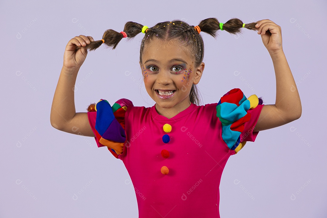 Menina linda sorrindo com mãos no cabelo e vestido coloriddo