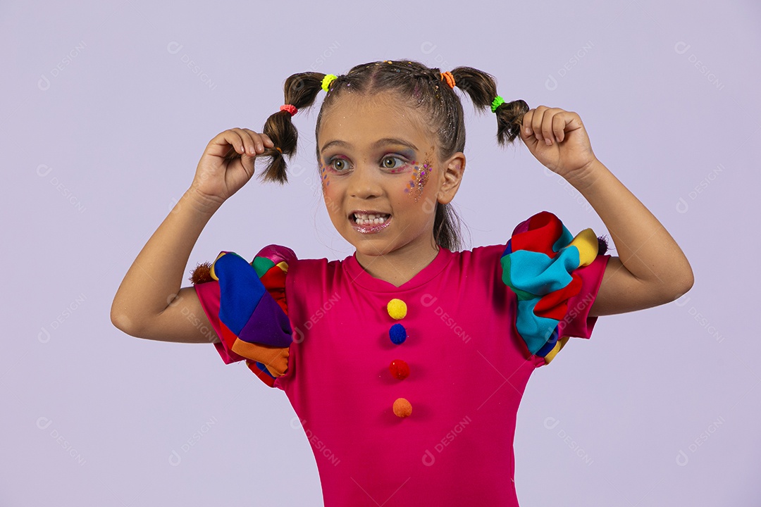 Menina fofa feliz segurando tranças vestida de roupa colorida