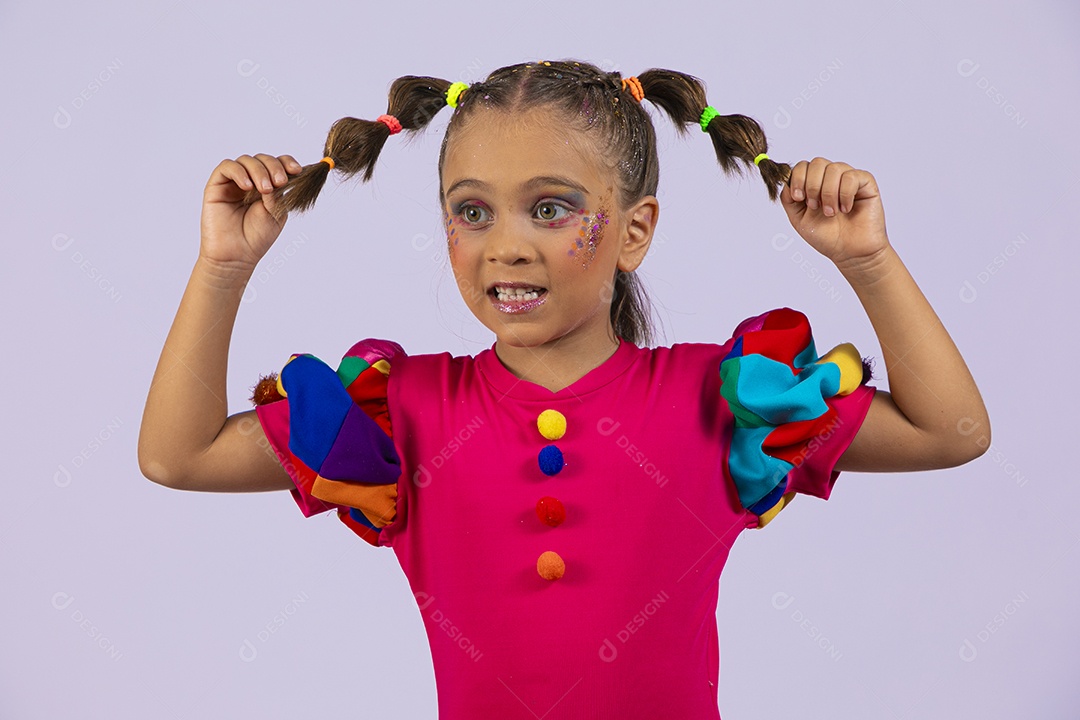 Menina fofa segurando nos cabelos feliz vestida de colorida