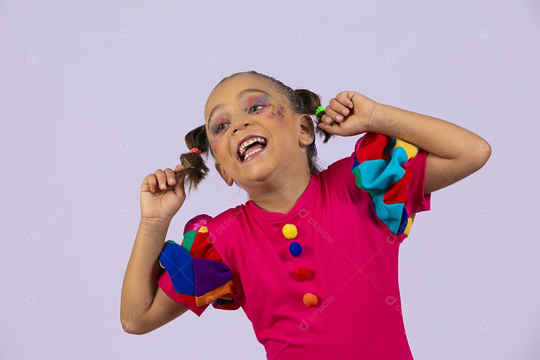 Menina fofa com roupa colorida pegando no cabelo e fazendo careta