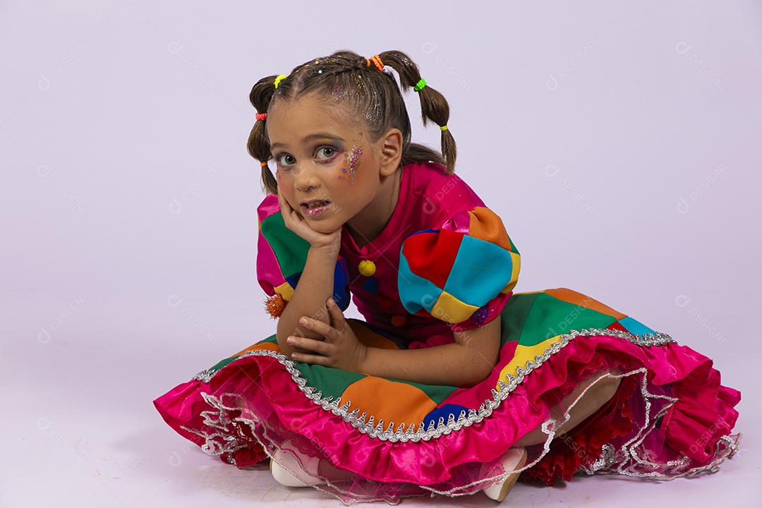 Menina fofa com posesenatada no chão e mãos no queixo