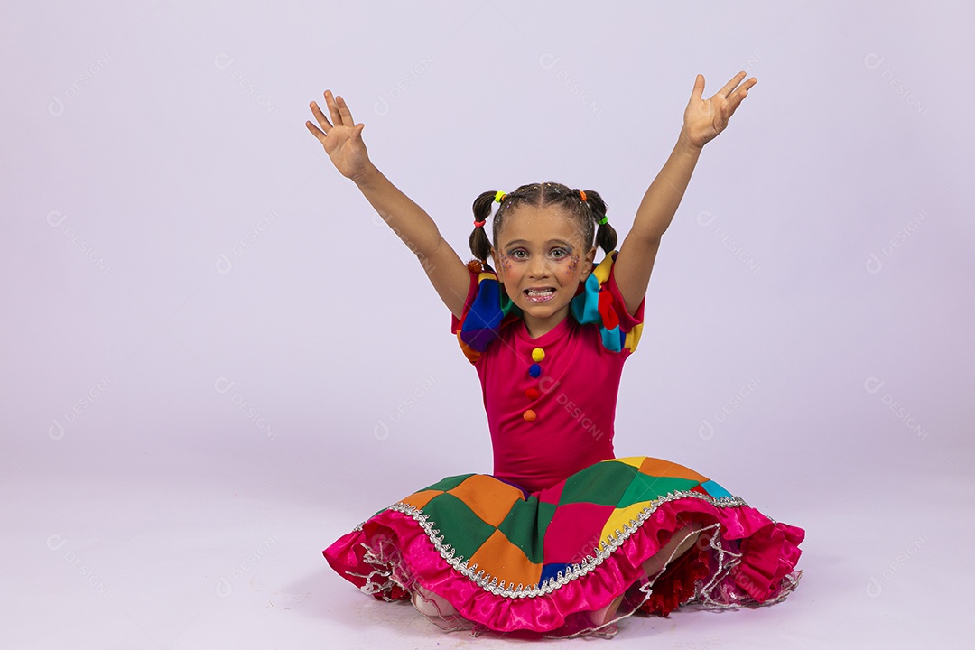 Garotinha linda vestida com roupa colorida com mãos para cima