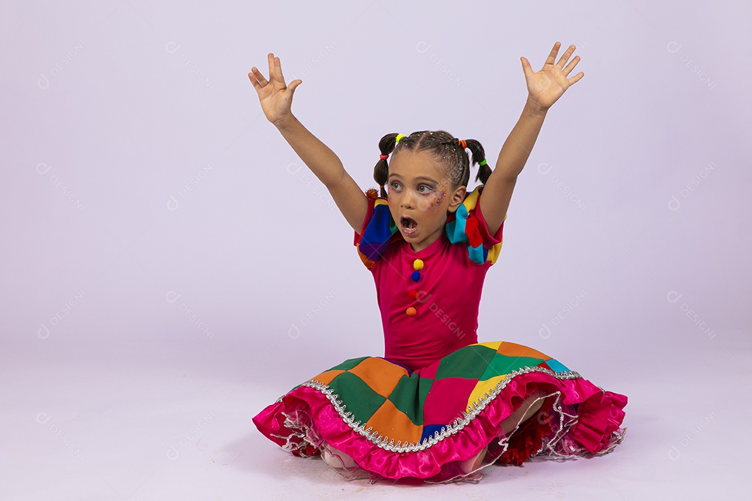 Garotinha fofa com roupa colorida com mãos para cima gritando