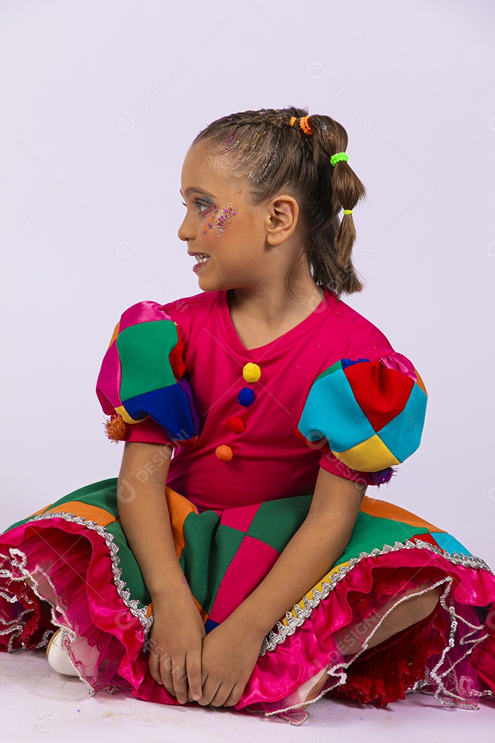 Menina de vestido colorido olhando para o lado bem feliz