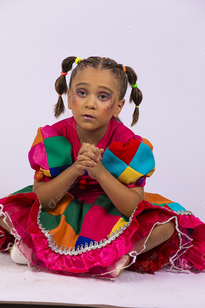 Menina fofa com vestido colorido e cara triste