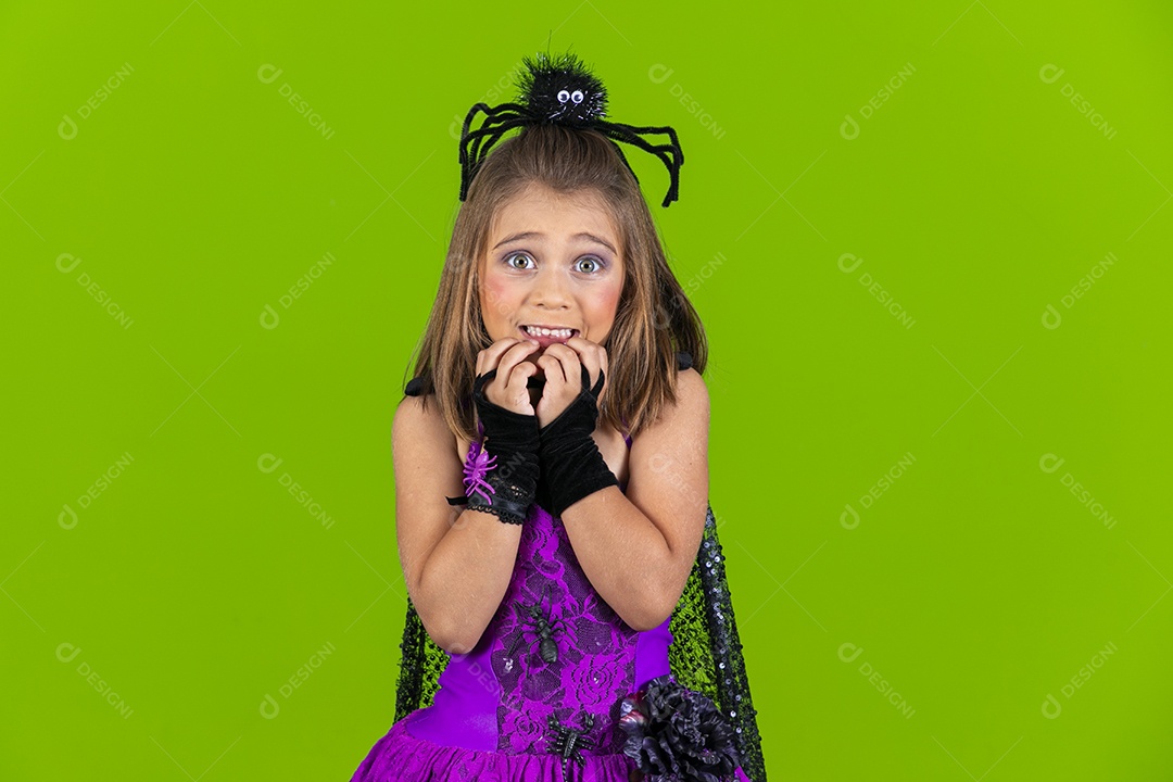 Uma adorável menina fantasiada com aranha na cabeça e gesto de medo
