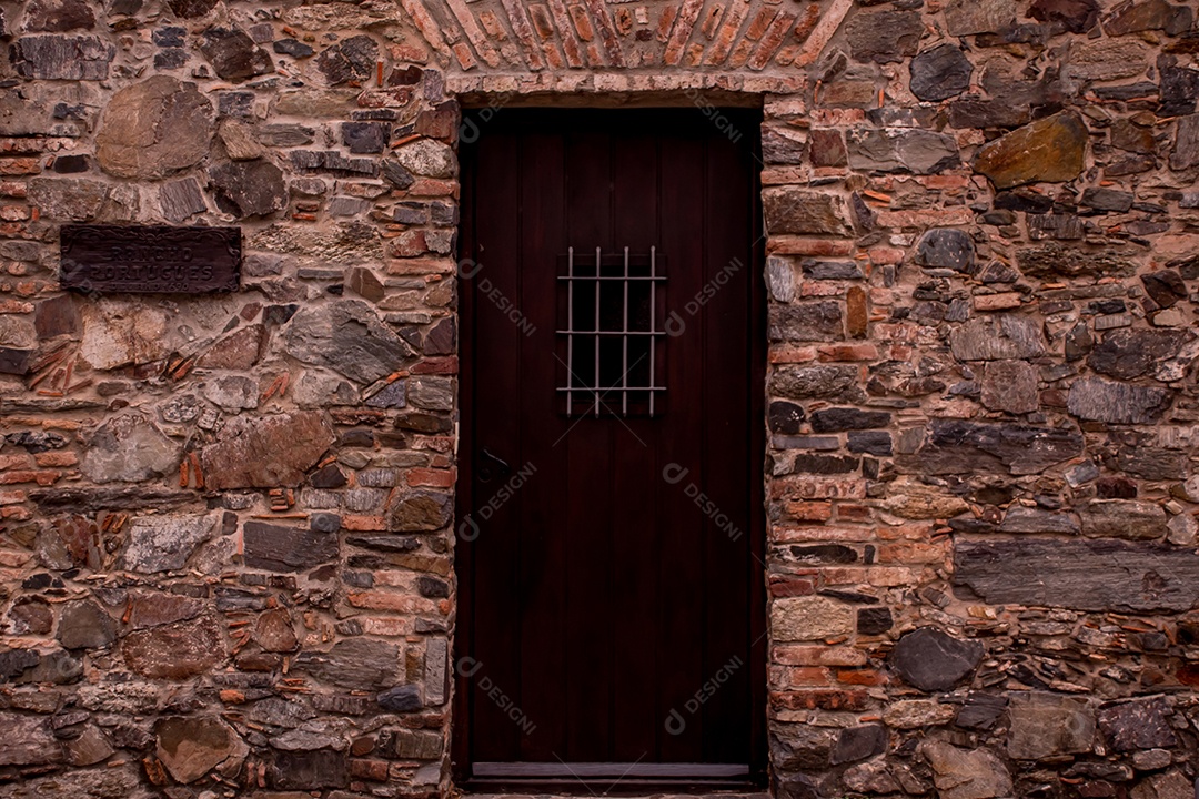 Detalhes do muro de pedra com porta antiga