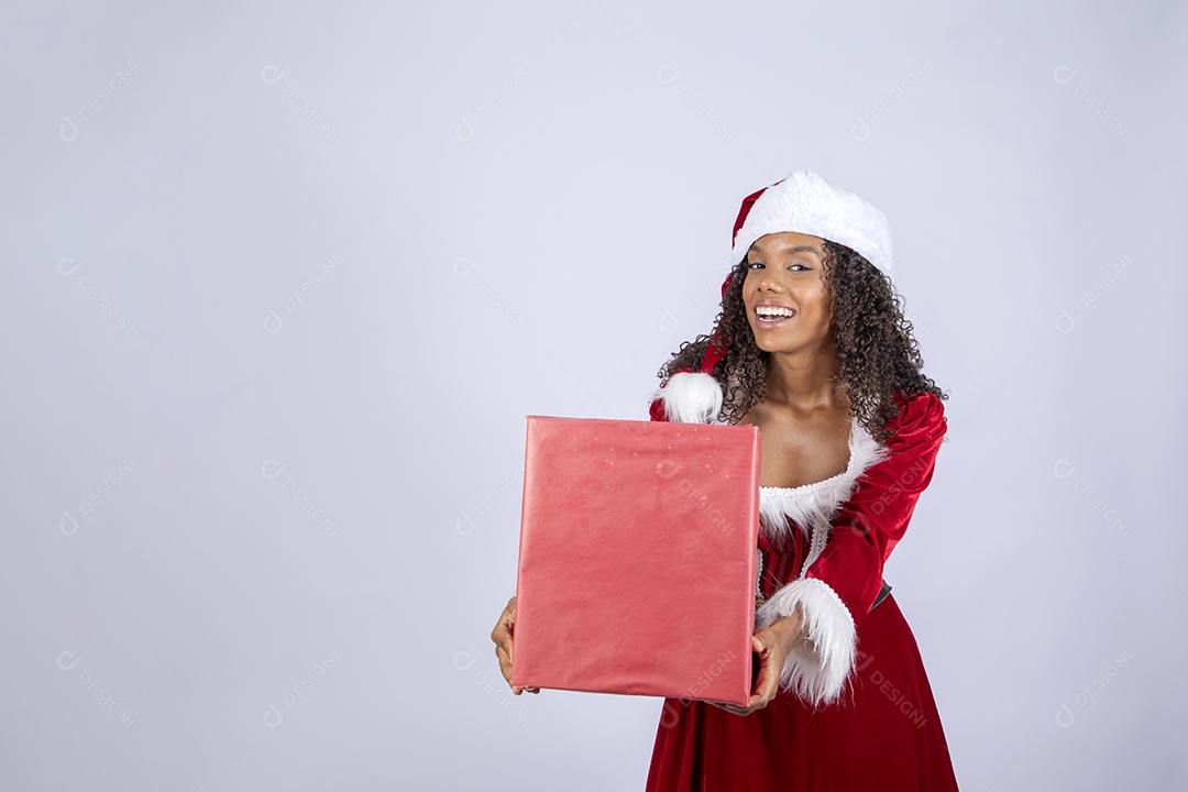 Jovem morena linda vestida de mamãe noel segurando presente