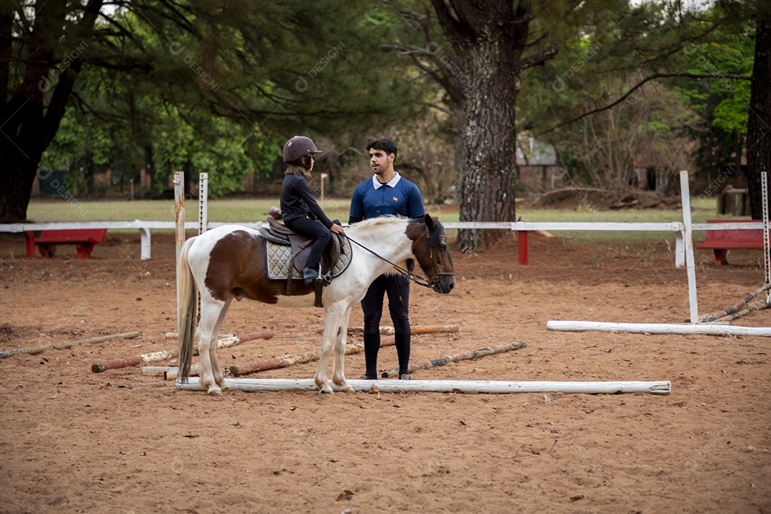 Aula de hipismo de uma garotinha linda