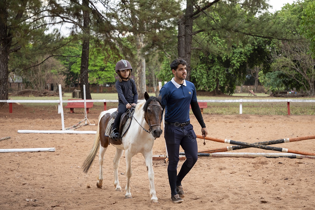 Aula de hipismo de uma garotinha linda