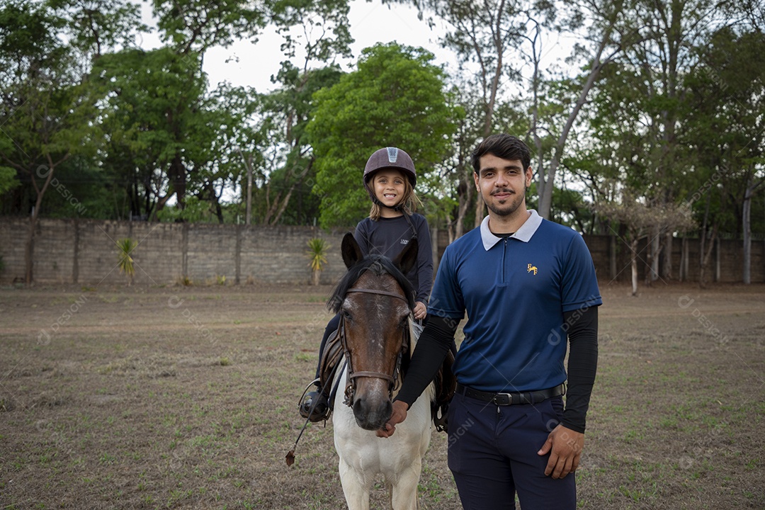 Amazonas em cima do cavalo e treinador ao lado