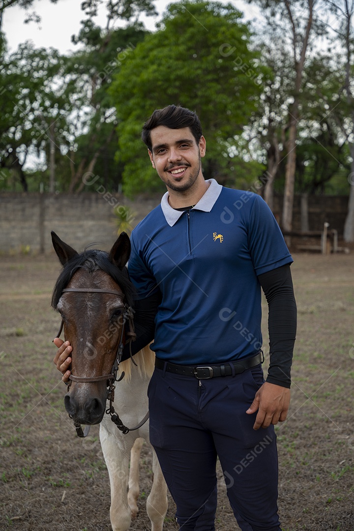 Treinador segurando na rédeas do cavalo